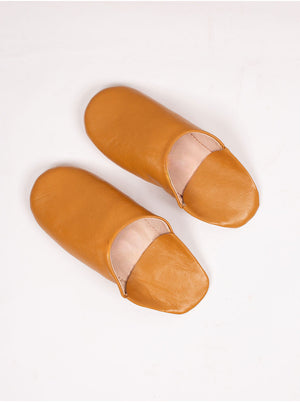 Babouches marocaines en cuir jaune moutarde vues de trois quarts sur fond blanc
