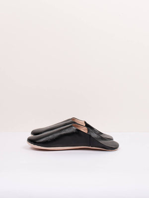 Paire de babouches marocaines en cuir noir sur fond blanc