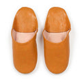 Paire de babouches marocaines en cuir moutarde sur fond blanc, vue de dessus