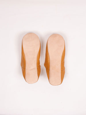 Semelles en cuir naturel d'une paire de babouches marocaines moutarde, vue de dessous