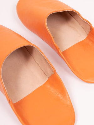 Détail de babouches marocaines en cuir orange, doublure en cuir naturel et coutures
