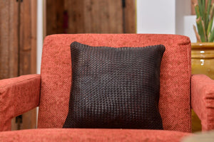 Détail du tissage d'un coussin en cuir tressé à la main, lanières de cuir marron entrelacées