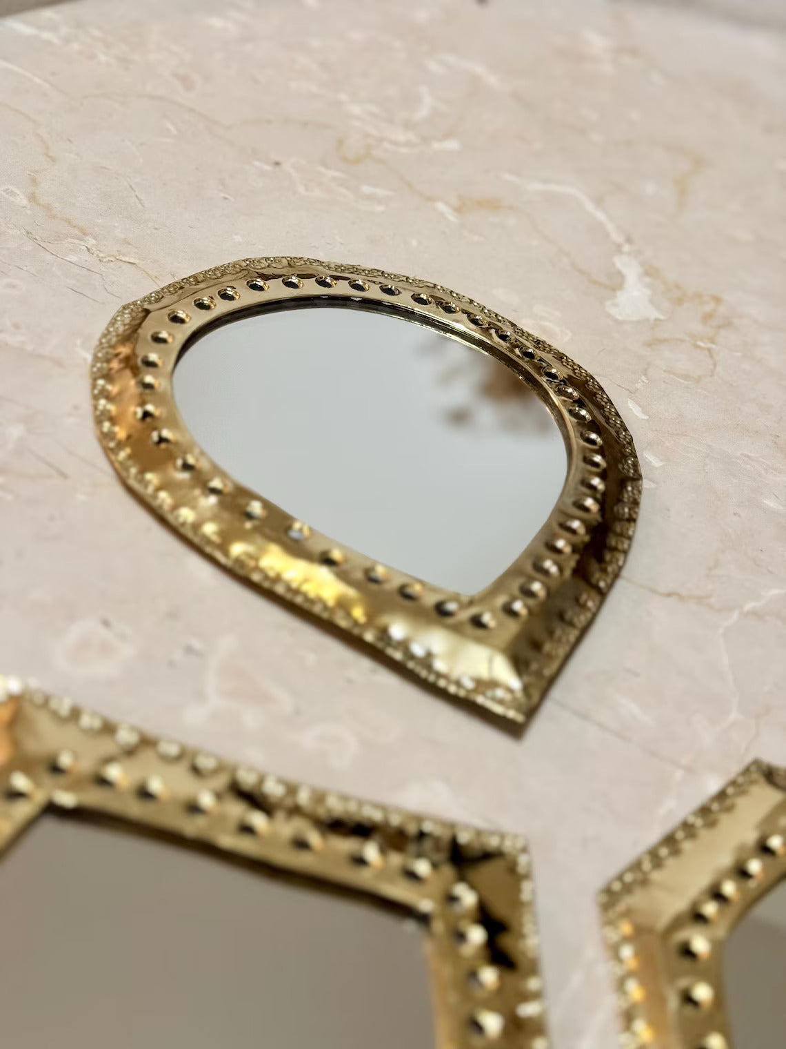 Gros plan sur un miroir marocain goutte d'eau en laiton, finition martelée et ciselée